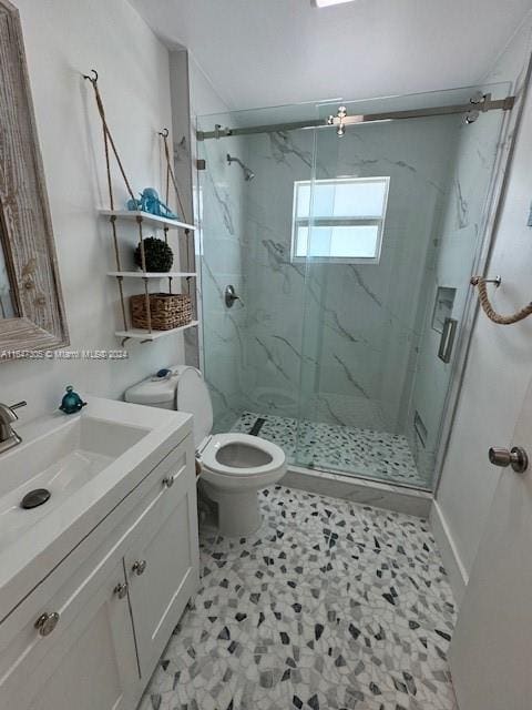 bathroom with toilet, vanity, a shower with door, and tile patterned floors