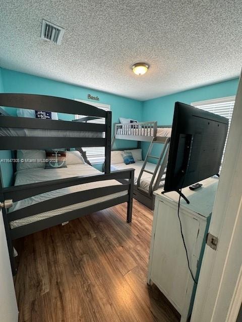 bedroom featuring a textured ceiling and light hardwood / wood-style flooring