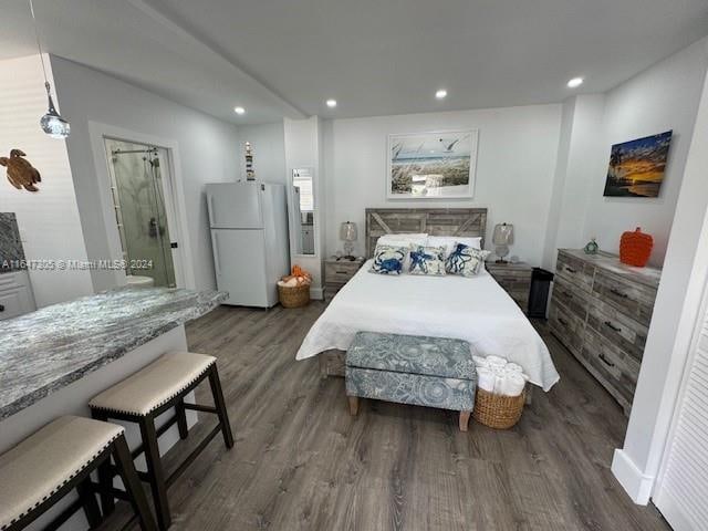 bedroom with white fridge and dark hardwood / wood-style floors