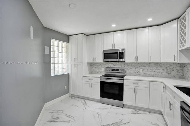 kitchen featuring stainless steel appliances, light tile patterned flooring, white cabinets, and tasteful backsplash