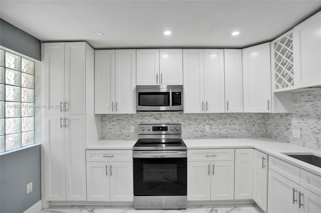 kitchen with white cabinetry, stainless steel appliances, and decorative backsplash