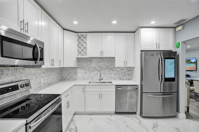 kitchen with sink, stainless steel appliances, white cabinetry, and light tile patterned floors