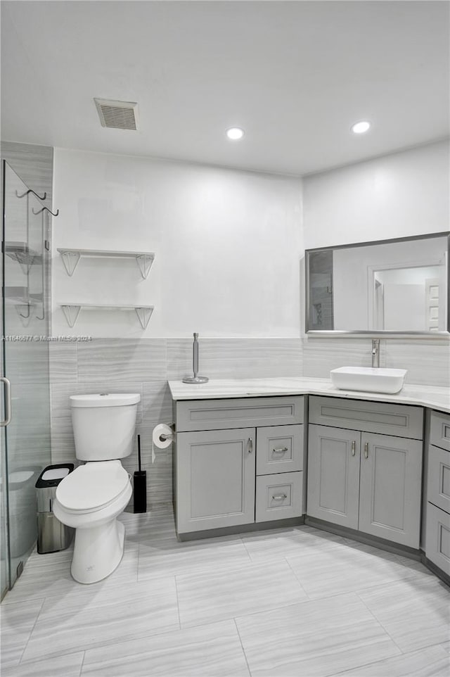 bathroom with tile walls, vanity, walk in shower, and tile patterned floors