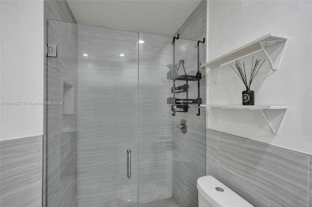 bathroom featuring an enclosed shower, toilet, and tile walls