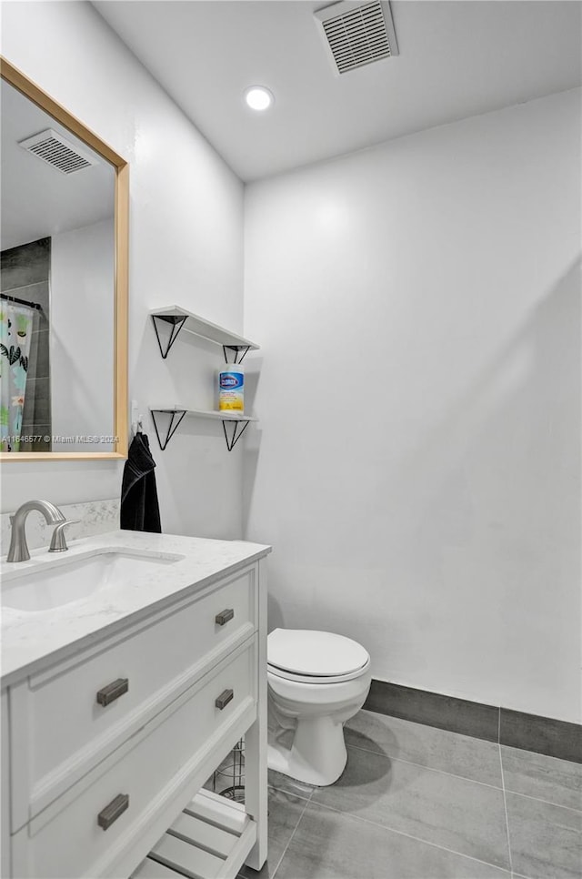 bathroom with toilet, tile patterned flooring, and vanity