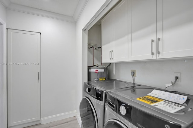 washroom featuring light hardwood / wood-style flooring, cabinets, washing machine and clothes dryer, crown molding, and electric water heater