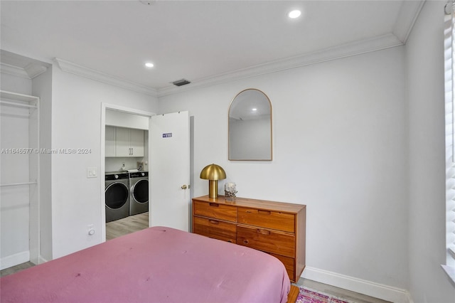 bedroom with light wood-type flooring, washer and clothes dryer, a closet, and ornamental molding