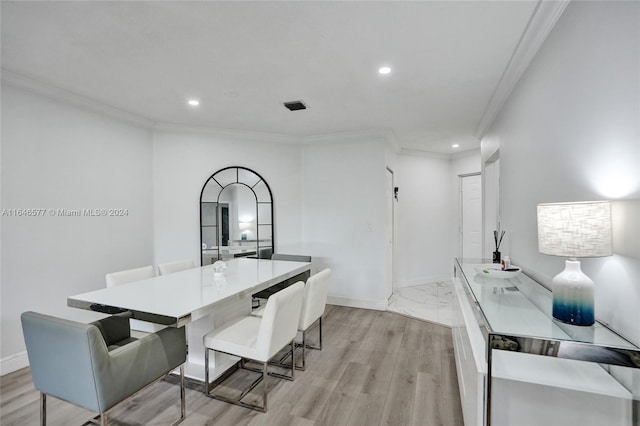 dining space with light hardwood / wood-style floors and ornamental molding