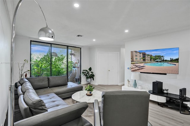 living room featuring light hardwood / wood-style flooring and crown molding