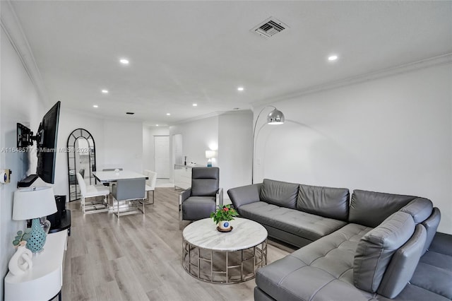 living room with light hardwood / wood-style floors and crown molding