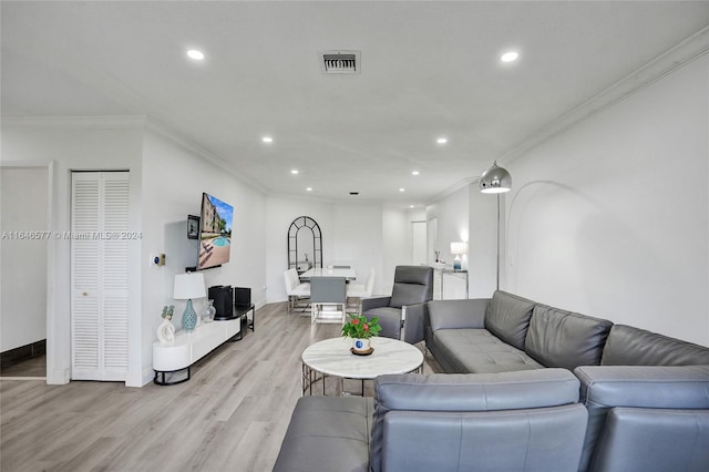 living room with light hardwood / wood-style flooring and crown molding