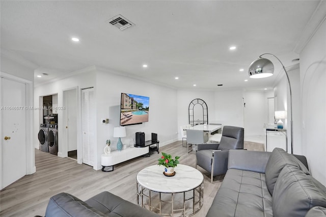 living room featuring light hardwood / wood-style floors, washer and dryer, and crown molding