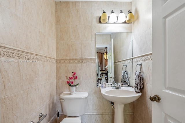 bathroom with toilet and tile walls