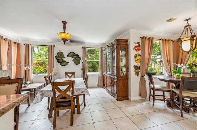 dining area with plenty of natural light, crown molding, and light tile patterned flooring