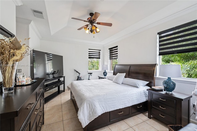 bedroom featuring ceiling fan, a raised ceiling, light tile patterned floors, and crown molding