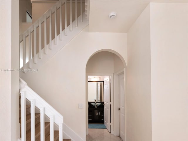 stairs featuring sink and tile patterned floors