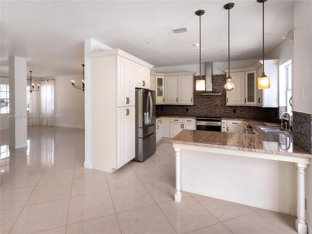 kitchen with wall chimney range hood, stainless steel fridge with ice dispenser, light tile patterned floors, sink, and kitchen peninsula