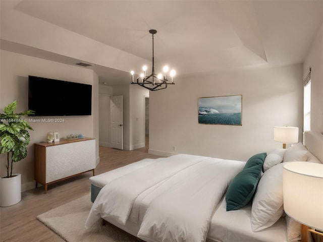 bedroom featuring hardwood / wood-style flooring and a notable chandelier