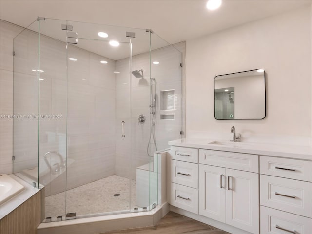 bathroom with shower with separate bathtub, vanity, and wood-type flooring