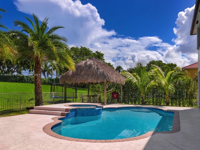 view of swimming pool featuring a lawn, a gazebo, an in ground hot tub, and a patio