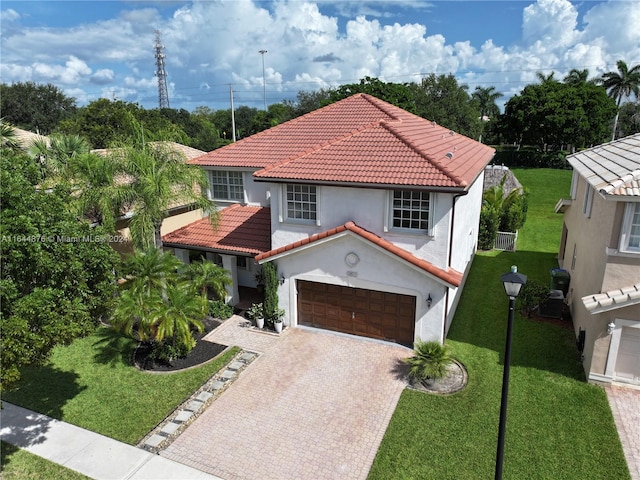 mediterranean / spanish-style house with a garage and a front lawn