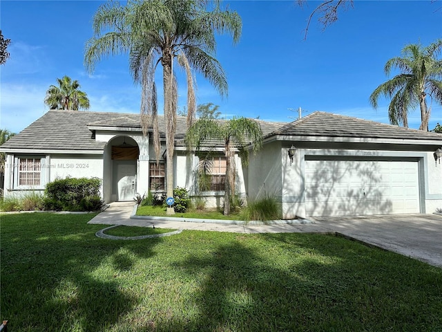 ranch-style house featuring a front lawn and a garage