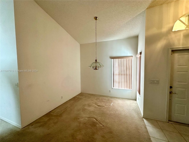 unfurnished dining area with a textured ceiling, lofted ceiling, and light carpet