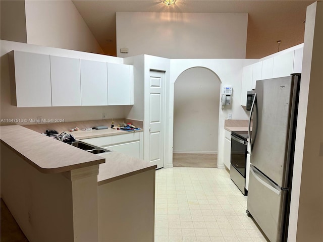 kitchen with sink, electric range oven, stainless steel refrigerator, light tile patterned floors, and kitchen peninsula