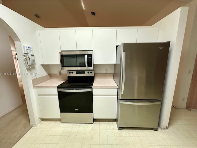 kitchen with white cabinets, appliances with stainless steel finishes, and light tile patterned floors