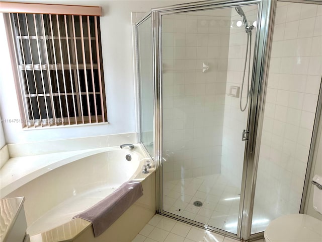 bathroom featuring plus walk in shower, toilet, and tile patterned floors