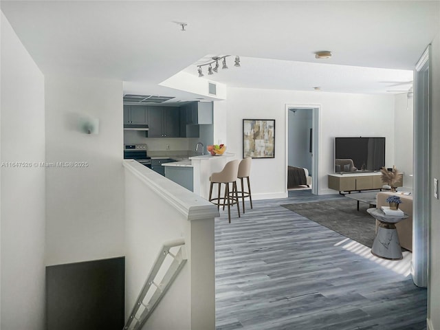 interior space with track lighting, dark wood finished floors, visible vents, and baseboards