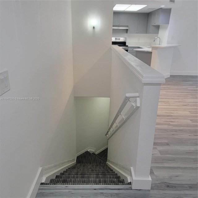 stairway with wood finished floors and baseboards