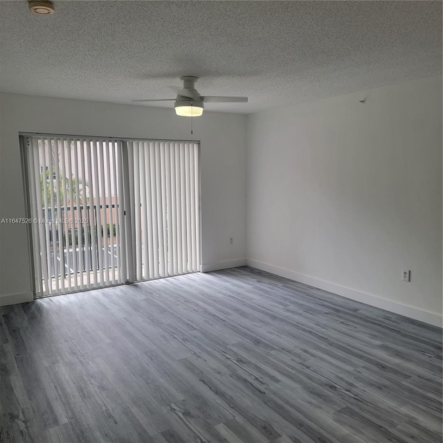 empty room featuring a ceiling fan, a textured ceiling, baseboards, and dark wood-style flooring