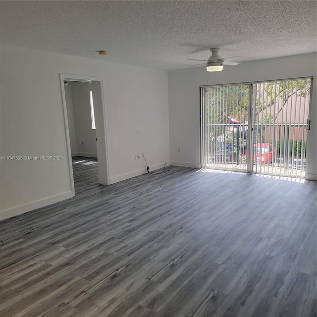 empty room with dark wood-style floors, ceiling fan, a textured ceiling, and baseboards