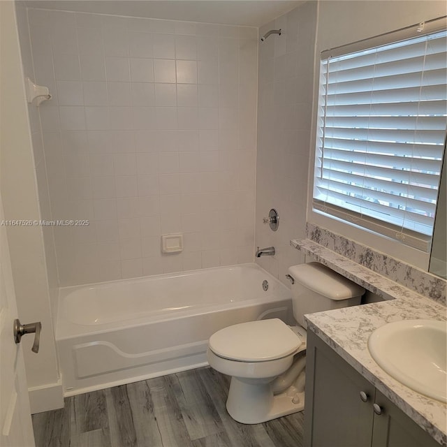 full bath featuring  shower combination, vanity, wood finished floors, and toilet