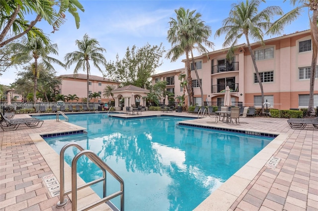 pool featuring fence and a patio