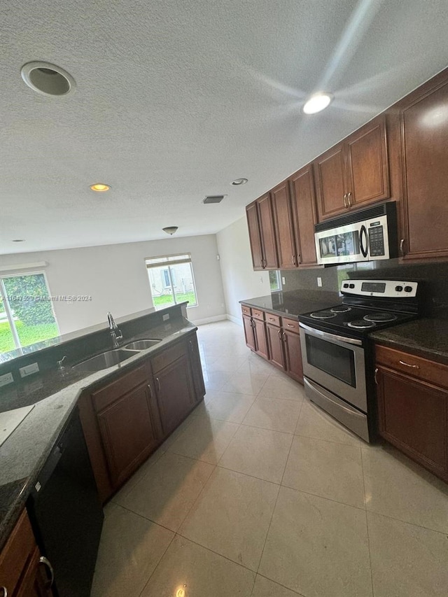 kitchen featuring appliances with stainless steel finishes, a textured ceiling, sink, and light tile patterned flooring