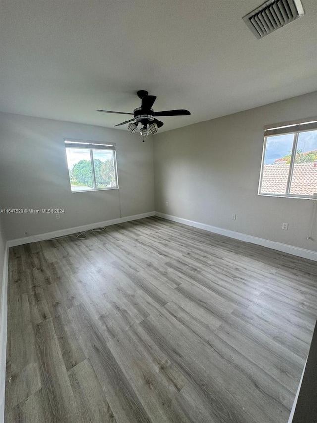 unfurnished room featuring a textured ceiling, ceiling fan, and light hardwood / wood-style floors