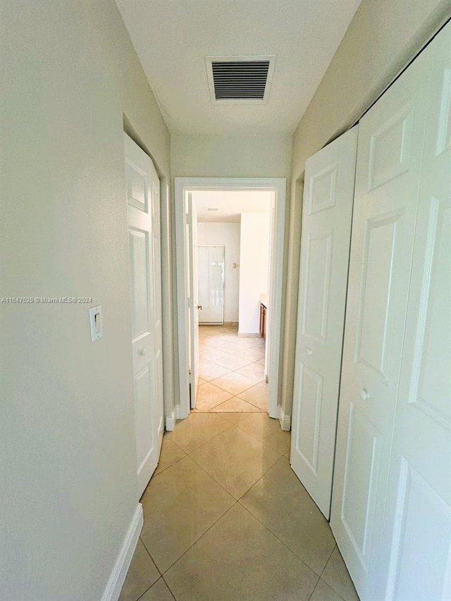 hall with light tile patterned floors