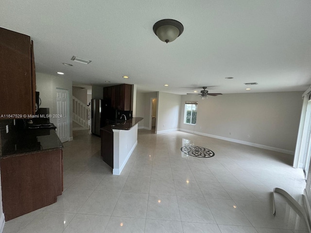 kitchen featuring a textured ceiling, sink, ceiling fan, stainless steel refrigerator with ice dispenser, and light tile patterned flooring