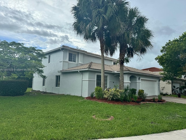 view of front of home with a front lawn and a garage