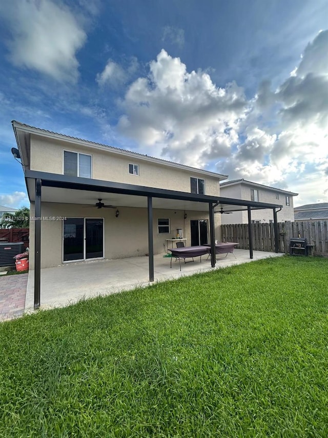 rear view of property featuring a patio area, a yard, and ceiling fan