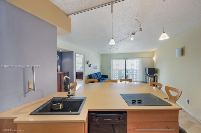 kitchen with sink, a kitchen island with sink, a textured ceiling, track lighting, and black appliances