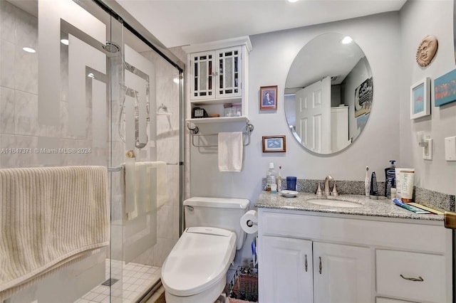 bathroom with vanity, toilet, and a shower with shower door