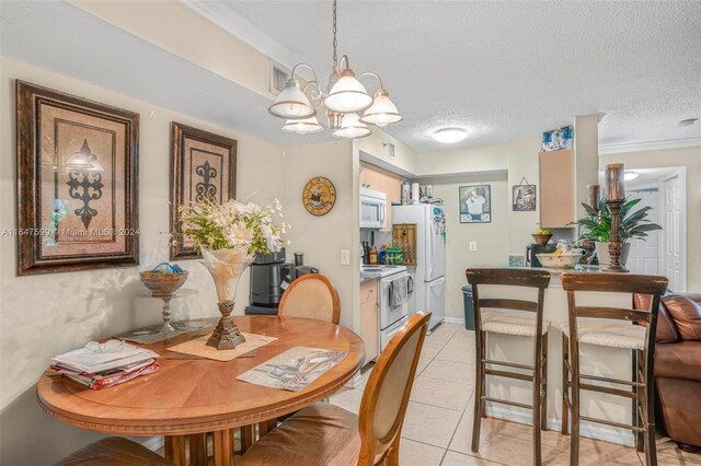 dining area with light tile patterned floors, crown molding, a notable chandelier, and a textured ceiling