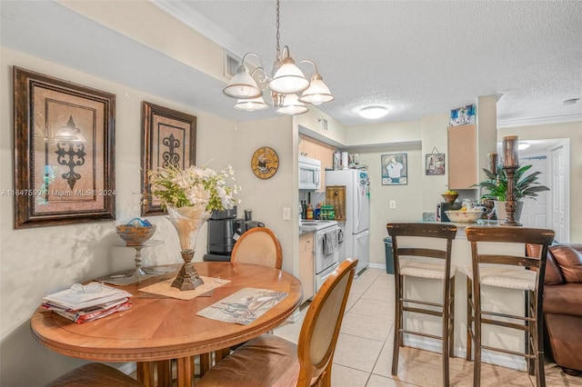 dining space with light tile patterned floors, ornamental molding, a textured ceiling, and an inviting chandelier