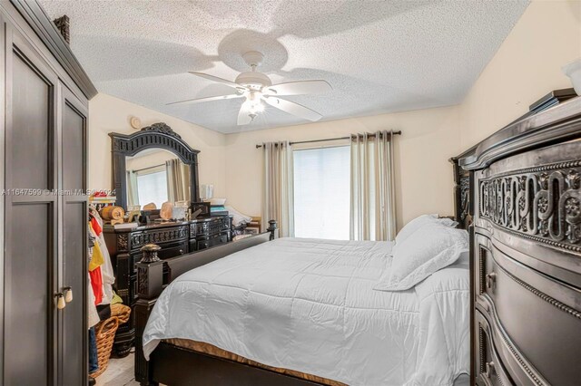 bedroom featuring ceiling fan and a textured ceiling