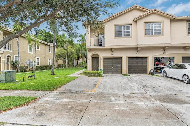 multi unit property featuring a garage, driveway, a front lawn, and stucco siding