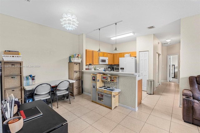 kitchen with light countertops, visible vents, open floor plan, white appliances, and a peninsula