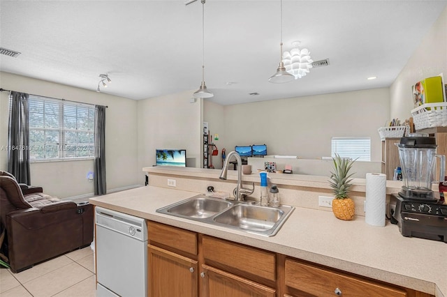 kitchen featuring open floor plan, light countertops, dishwasher, and a sink